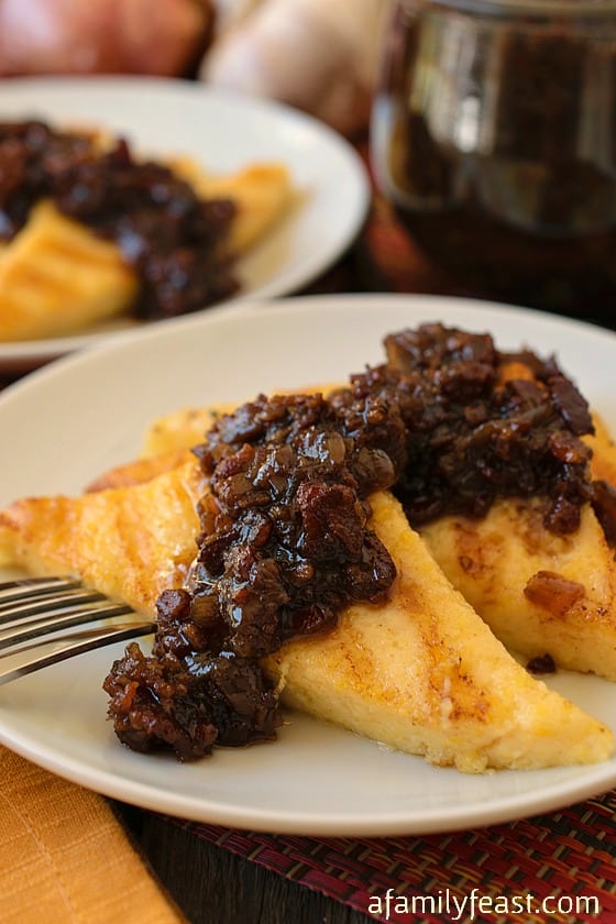 Grilled Polenta with Bacon Jam - Pure, delicious comfort food! Cheesy creamy polenta slices topped with an amazing bacon jam. Fantastic!
