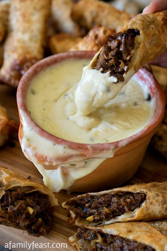 Cheesesteak Egg Rolls - Tender shredded beef brisket in crispy fried egg rolls, served with a zesty queso dipping sauce. Amazing!