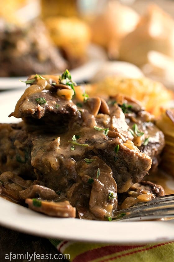 Slow Cooker Swiss Steak - Fork-tender beef cooked in the crockpot with a rich delicious onion and mushroom gravy. Pure comfort food!