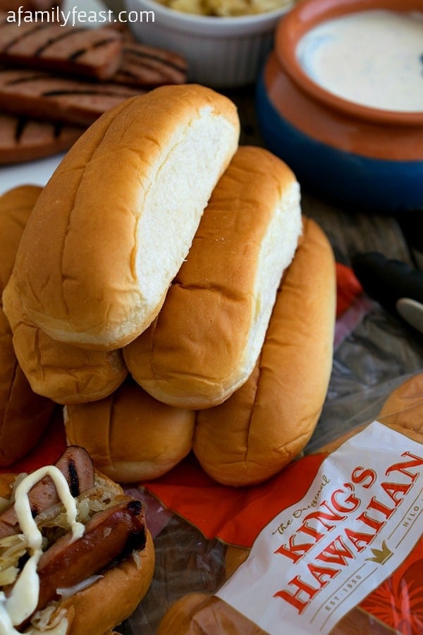 Grilled Kielbasa Rolls - Grilled Kielbasa smothered in sauerkraut & onions, swiss cheese and zesty white barbecue sauce - all piled into a KING'S HAWAIIAN Hot Dog Roll! #MakeSummerSweet